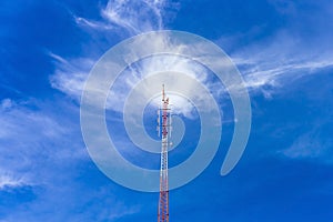 Telecommunication radio wave signal tower red and white with cloudy. Steel truss of transmission signal antenna with blue sky.