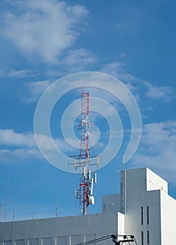 Telecommunication tower against the blue sky with clouds