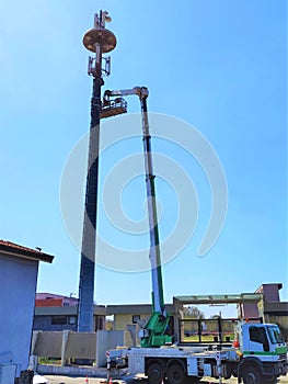 Telecommunication tower with antennas against blue sky background with copy space