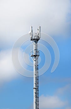 Telecommunication tower with antennas on a background of blue sky and clouds. Smart antennas transmit 4G and 5G cellular signals