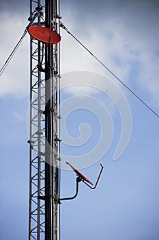 Telecommunication tower with antennas on blue sky.