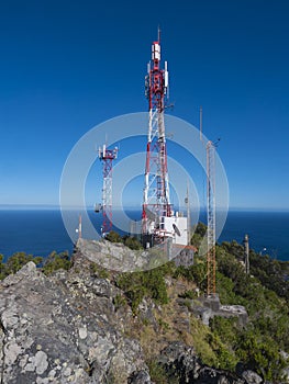 Telecommunication tower with antennas and blue sky background at Pico do Facho hill viewpoint, Machico, Madeira