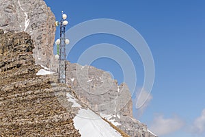Telecommunication tower with antennas and satellite dish. Development of communication systems in mountain areas.