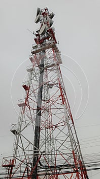 Telecommunication tower from below with cloudly sky behind