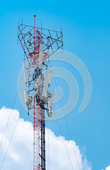 Telecommunication tower with blue sky and white clouds background. Antenna on blue sky. Radio and satellite pole. Communication
