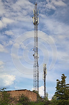 Telecommunication tower cell for mobile communications against cloudy sky. One base radio station