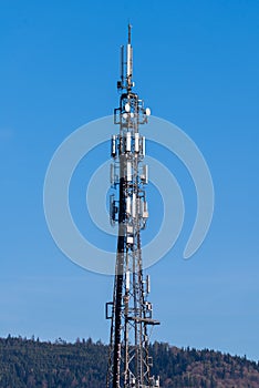 Telecommunication tower with cellular network antenna against blue sky as background