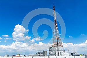 Telecommunication tower with a cloud and bluesky. Used to transmit television. Antenna with blue sky in the city