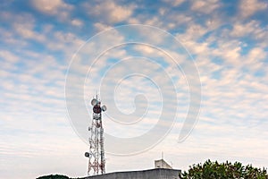 Telecommunication tower in communication industry technology with cloudy dramatic sunset sky