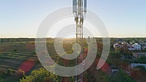 Telecommunication tower, drone view on cellular antenna with man in safety vest and hard hat get down with the help of