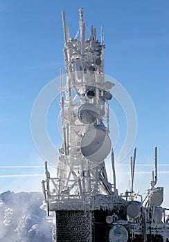 Telecommunication tower frozen under blue sky photo