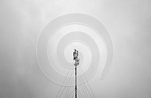 Telecommunication tower or mast against grey sky in black and white