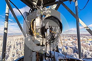 Telecommunication tower or mast with microwave, radio panel antennas, outdoor remote radio units, power cables, coaxial