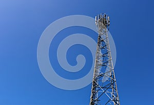 Telecommunication tower or mast with microwave, radio panel antennas, outdoor remote radio units, power cables, coaxial