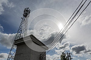 Telecommunication tower or mast with microwave, radio panel antennas, outdoor remote radio units, power cables, coaxial