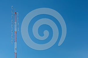 Telecommunication tower mast TV and radio antenna on blue sky