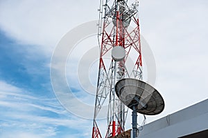 Telecommunication tower with satellite dish, on blue sky