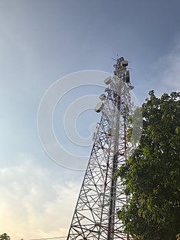 Telecommunication tower and tree at evening