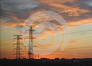 Telecommunication towers against a sunrise sky with the early morning glow on clouds