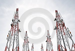 Telecommunication towers with TV antennas and satellite dish on clear sky, black and white
