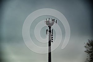 Telecommunications antennas tower silhouette under dull sky