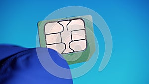 Telecommunications engineer sees nano SIM card 4g mobile phone on blue background