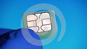 Telecommunications engineer sees nano SIM card 4g mobile phone on blue background