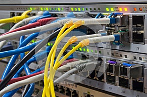 Telecommunications rack with switches and colored UTP and fiber