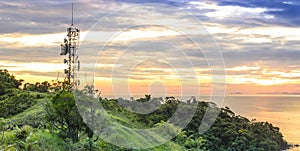 Telecommunications and radio towers with sunset sky in background .