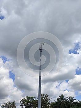 Telecommunications tower against clouds sky background