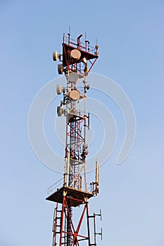 Telecommunications tower and satellite dish telecom network on blue sky with bright sun light