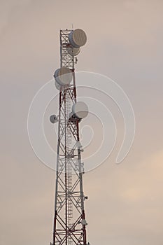 Telecommunications tower and satellite dish telecom network on evening sky