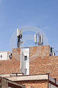 Telecommunications wireless cell phone antennas on the roof of a building. 5g high speed internet transmitters