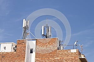 Telecommunications wireless cell phone antennas on the roof of a building. 5g high speed internet transmitters