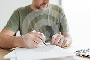 Telecommuter writing project notes in home office