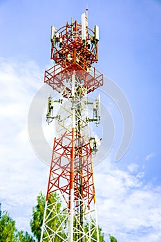 Telecoms tower with transmitter antenna on the bright blue sky background