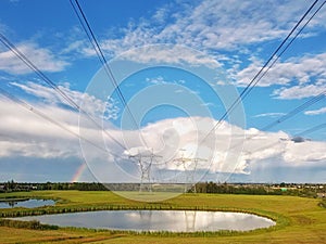 Telegraph poles and rainbow after a rain in summer