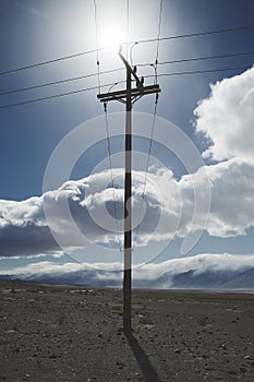 Telegraph utility pole silhouette in desert