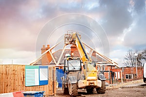 Telehandler moving roof trusses on new  housing development building site site