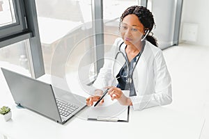 Telehealth, African American doctor in headset consulting with the patient over the phone call. Health care call center
