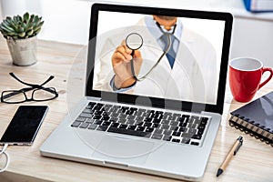 Telemedicine concept. Doctor GP on a computer screen, office desk background photo