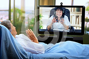 A telemedicine geriatrics communicates in real time with a sick elderly patient.
