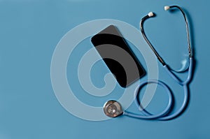 Telemedicine or telehealth, remote doctor video chat consultation concept with smartphone and stethoscope on blue background photo