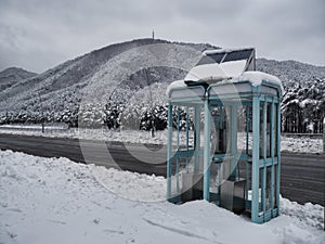 Telephone booth on a snow-covered mountain road
