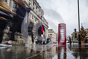 Telephone cabin in London with people`s frenzy catched with long exposition