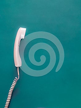 Telephone handset on green with copy space