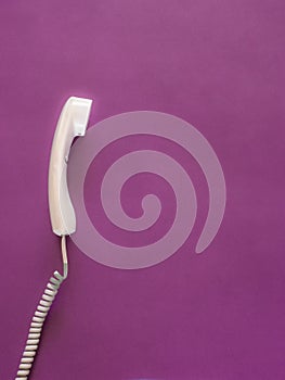 Telephone handset on pink with copy space