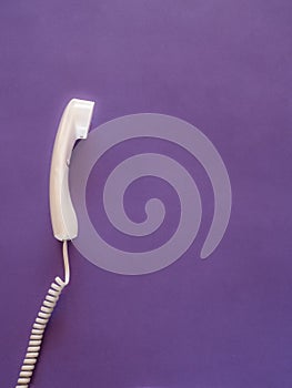 Telephone handset on purple with copy space