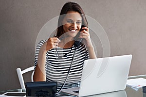 Telephone, happy and business woman with laptop in conversation, talk or listen to contact with glasses in startup