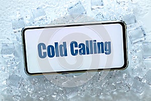 A telephone lying in the ice with the words `cold calling` Pharse, business concept of contacting and establishing cooperation photo